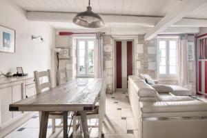 - un salon avec une table en bois et un canapé dans l'établissement Maison Salicorne, à La Flotte