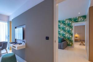 a living room with a desk and a television in a room at Skiathos Palace Hotel in Koukounaries