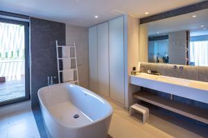 a bathroom with a large white tub and a sink at Skiathos Palace Hotel in Koukounaries