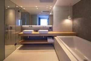 a bathroom with two sinks and a bath tub at Skiathos Palace Hotel in Koukounaries
