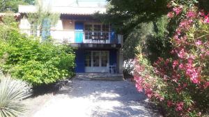 een blauw huis met een balkon en een aantal struiken bij baraveou home in nature in Le Plan