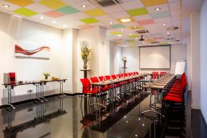 a conference room with red chairs and a projection screen at Art Hotel William in Bratislava