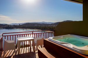 a hot tub on a balcony with a view of a river at Skiathos Palace Hotel in Koukounaries