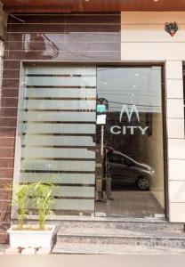 a store window with a car in the reflection at Hotel M City in Amritsar