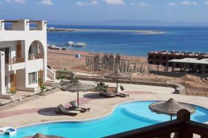 a view of a resort with a swimming pool and the ocean at Awesome View in Dahab