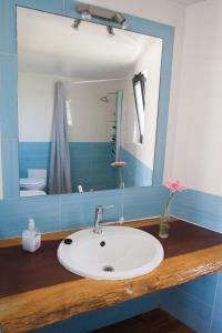 a bathroom with a white sink and a mirror at Good Feeling Hostel & Guest House in Raposeira