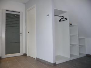 Zimmer mit weißen Wänden und einem Schrank mit einer Tür in der Unterkunft Charmant sudio aux portes de Colmar in Durrenentzen