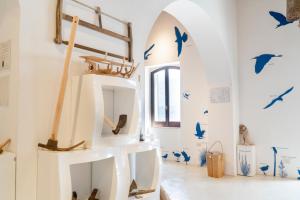 una stanza con uccelli blu sul muro di MuMA Hostel a SantʼAntìoco