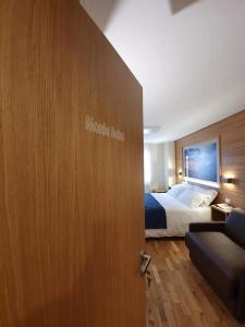 una porta che conduce a una camera d'albergo con letto e divano di Hotel Miramonti a Castel del Monte