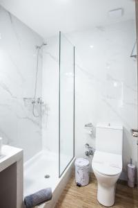 a white bathroom with a shower and a toilet at Trikala River House in Tríkala