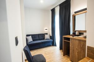 a living room with a blue couch and a desk at Trikala River House in Tríkala