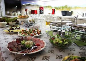 a buffet with plates of food on a table at Villa Sopocka in Sopot