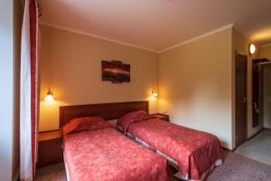 two beds in a hotel room with red covers at Baza Otdykha Losevo Park in Losevo