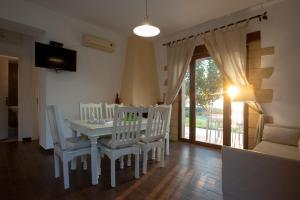 a dining room with a white table and chairs at Sunset Villas in Falasarna