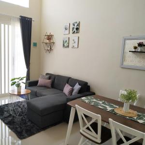 uma sala de estar com um sofá e uma mesa em Villa Kayana F15 - 2 Bedroom Full AC em Karangploso