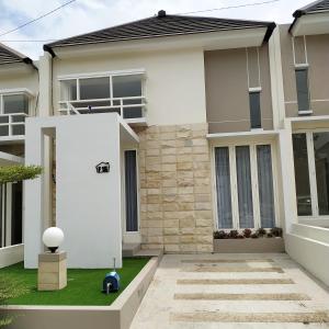 uma casa com uma porta branca num quintal em Villa Kayana F15 - 2 Bedroom Full AC em Karangploso