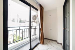 a room with a large window and a balcony at RoomQuest Sukhumvit36 BTS Thonglor in Bangkok