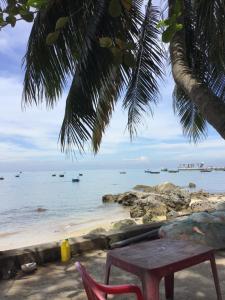 a table and a chair sitting on a beach at Tám Thọ homestay in Tân Hiệp