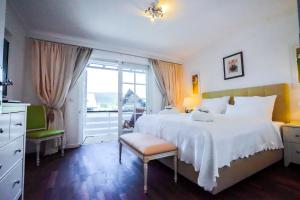 a bedroom with a large white bed and a window at Bergkranz Apartments in Seefeld in Tirol