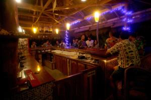 a group of people sitting at a bar in a restaurant at JJS BACKPACKERS VILLAGE in Siquijor
