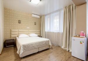 ウラジオストクにあるカルメンのベッドルーム(白いベッド1台、冷蔵庫付)