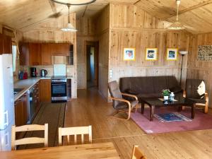 a kitchen and living room with a couch and a table at Domki Green Grzybowo in Grzybowo