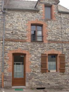 un edificio de piedra con 3 ventanas y una puerta de madera en gite colorado, en Renac