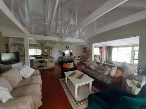 una gran sala de estar con sofás y TV. en De' Nessie en Port Alfred