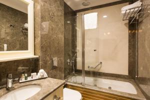 a bathroom with a shower and a sink and a tub at GLK PREMIER Sea Mansion Suites & Spa in Istanbul