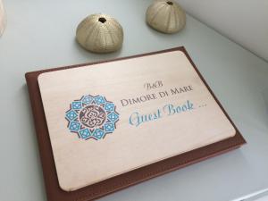 a sign on a wall with a guest book at Dimore di Mare in San Pietro Vernotico