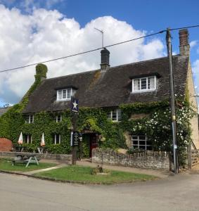 una casa cubierta de hiedra con una calle en The Star Inn en Sulgrave