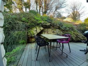 ein Tisch und Stühle auf einem Holzdeck in der Unterkunft Holiday home De la Corniche in Annecy