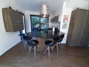 una cocina con mesa negra y 4 sillas en Holiday home De la Corniche, en Annecy