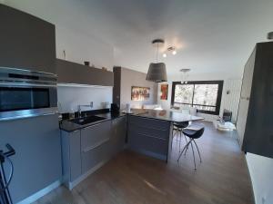a kitchen with a sink and a table in it at Holiday home De la Corniche in Annecy