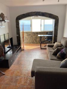a living room with a couch and a table at Apto boca cangrejo Netflix,parking,aire acondicionado y rent car in Santa Cruz de Tenerife +17 photos