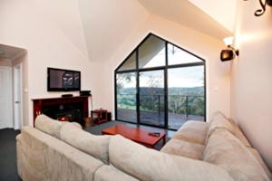 ein Wohnzimmer mit einem Sofa und einem großen Fenster in der Unterkunft Scarlet Woods in Quinninup
