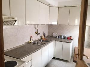 a kitchen with white cabinets and a sink at Lydia Center Apartment in Veles
