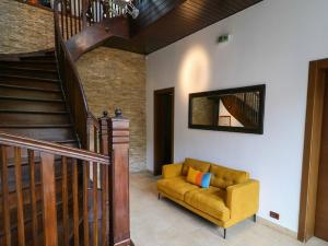 a living room with a yellow couch and stairs at Villa Prato in Braşov