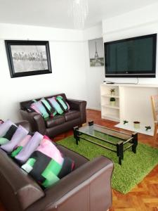 a living room with two leather couches and a flat screen tv at Home from Home, Great Community!! in London