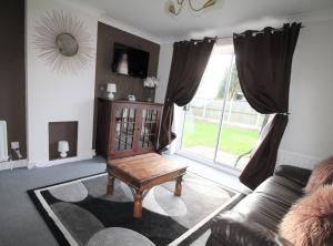 a living room with a couch and a table and a window at Doncaster - Hatfield - Large Private Garden & Parking - 2 Bedroom House - Very Quiet Cul De Sac Location in Doncaster