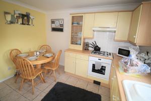 a kitchen with a table and chairs and a kitchen with yellow cabinets at Doncaster - Hatfield - Large Private Garden & Parking - 2 Bedroom House - Very Quiet Cul De Sac Location in Doncaster