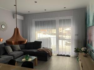 a living room with a couch and a large window at Apartament Miedziany in Szczyrk