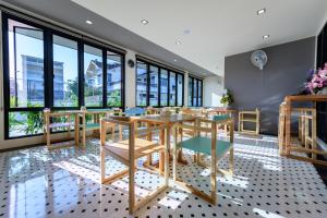 a dining room with a table and chairs and windows at Top Residence in Suratthani