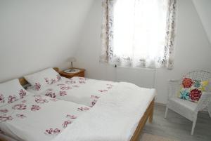 een slaapkamer met een bed, een stoel en een raam bij Ferienhaus Breithaupt in Cuxhaven