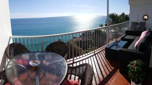 a table and chairs on a balcony with the ocean at Carabeo Vista Mar in Nerja