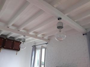 three glass lights hanging from a white ceiling at House Orizzonte - Casa Bianca in Genoa