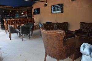 een wachtkamer met lederen stoelen en een tafel bij Pent House Inn Namugongo in Kampala