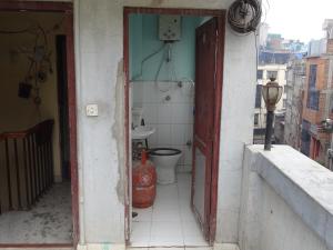 une porte ouverte menant à une salle de bains pourvue de toilettes. dans l'établissement Green House Lodge, à Katmandou