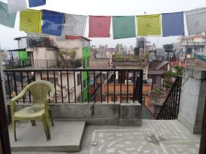 une chaise verte assise au-dessus du balcon dans l'établissement Green House Lodge, à Katmandou