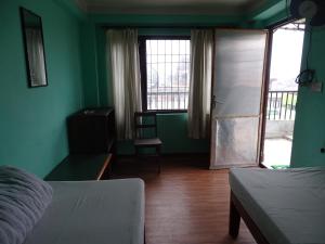 Cette chambre est dotée de murs verts et d'une porte. dans l'établissement Green House Lodge, à Katmandou